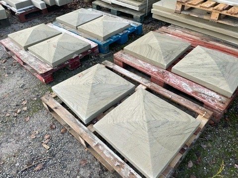 Pyramid-topped sandstone pier caps on pallets in the yard